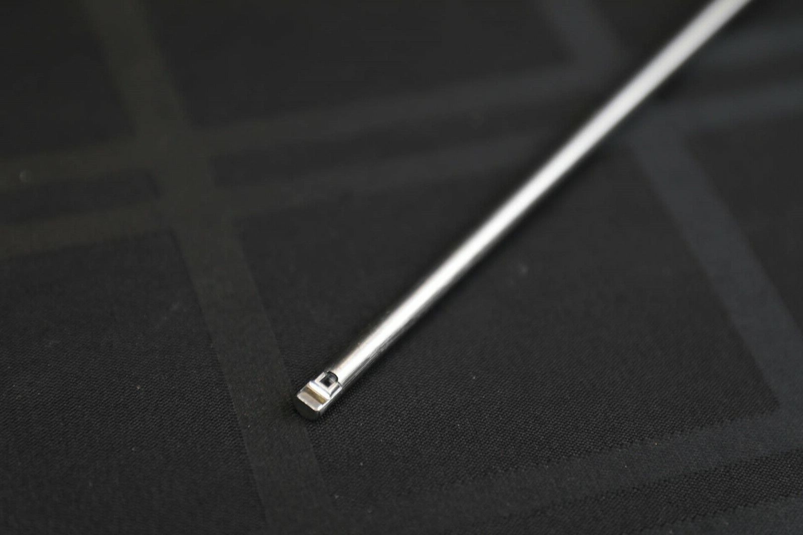 Close-up of metal rod on black textured background